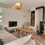 Le salon, avec un grand canap&eacute;, une banquette et un fauteuil en rotin ann&eacute;es 60 chin&eacute; 