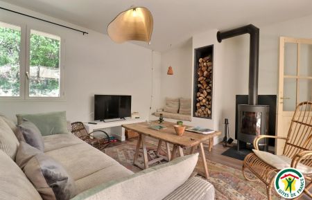 Le salon, avec un grand canapé, une banquette et un fauteuil en rotin années 60 chiné Gîte n°G102009 Condillac - Drôme - Le salon, avec un grand canapé, une banquette et un fauteuil en rotin années 60 chiné